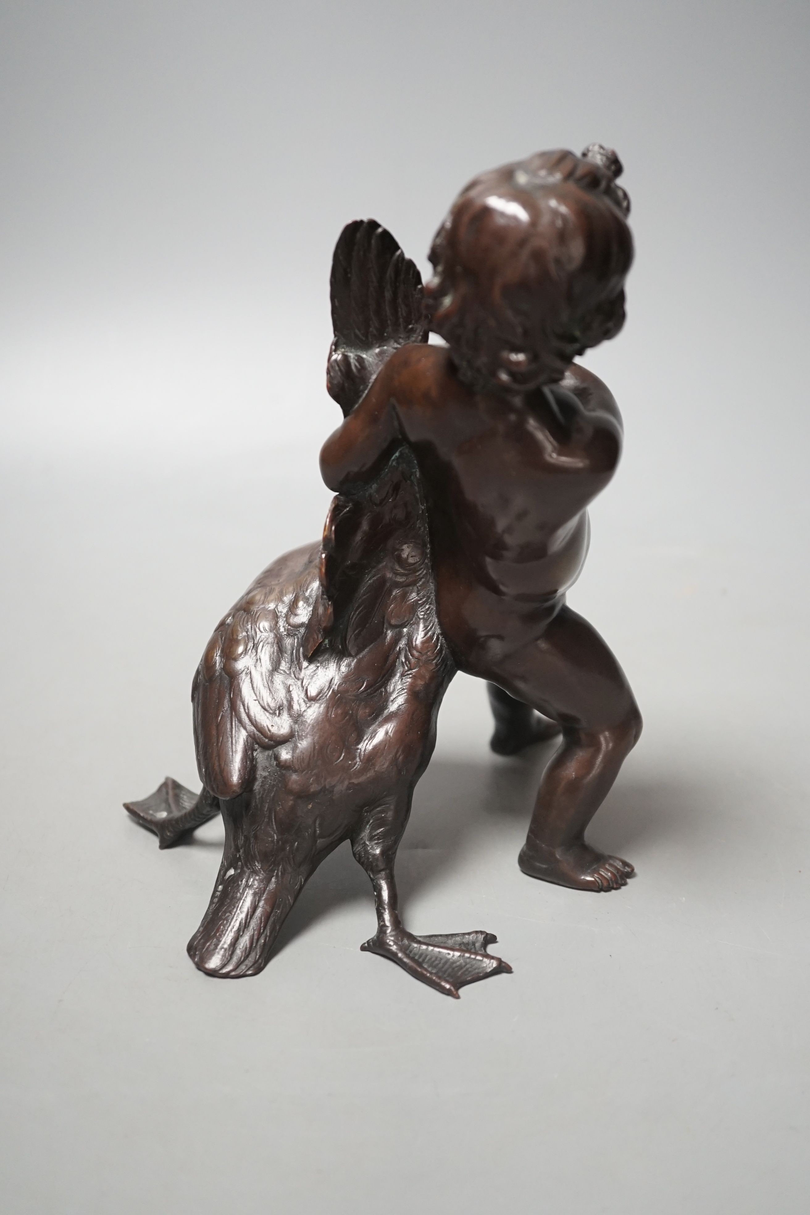 A Carl Karuba bronze of a cherub holding a goose, 17.5 cms high.